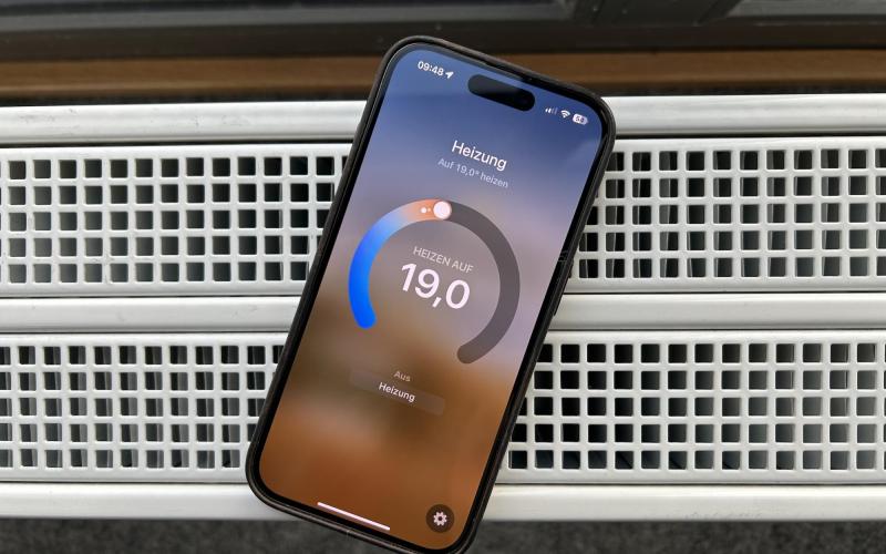 Handy mit smarter Heizungsregelung via App auf Heizung